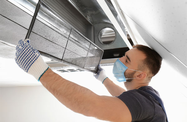 A man cleaning an air duct.