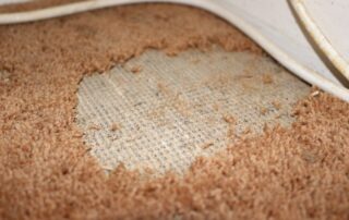 This image shows a damaged carpet that will be replaced.